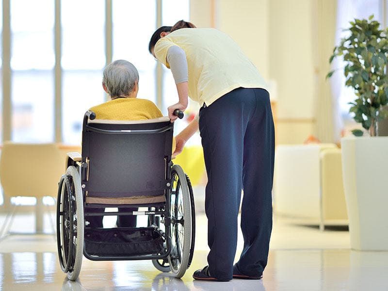車椅子の老人と介護士